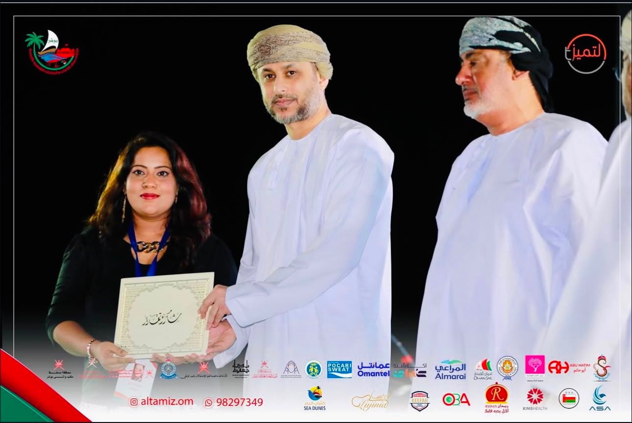 Sarah Khan receiving an award at a formal Omani ceremony